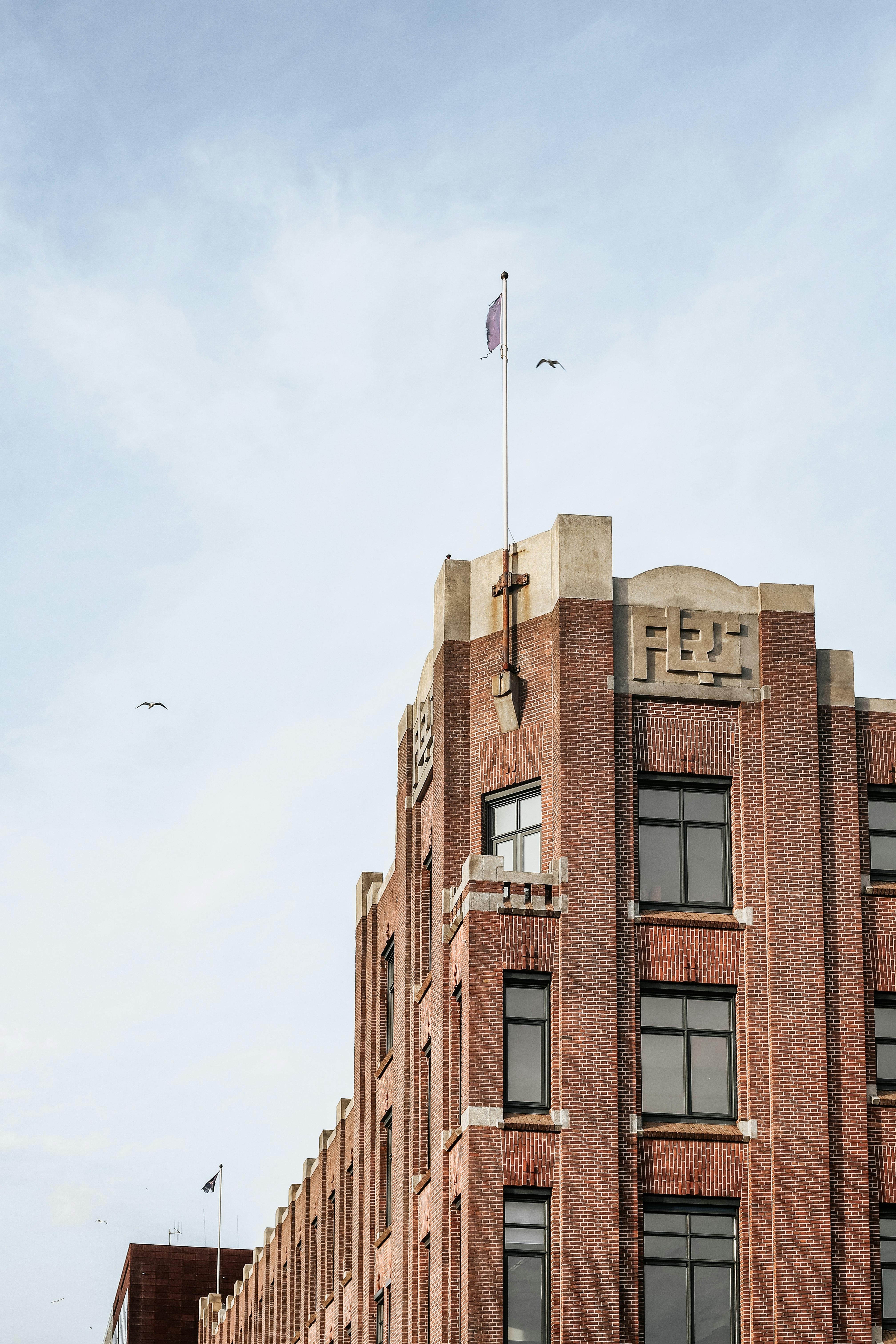 brown concrete building with white flag on top